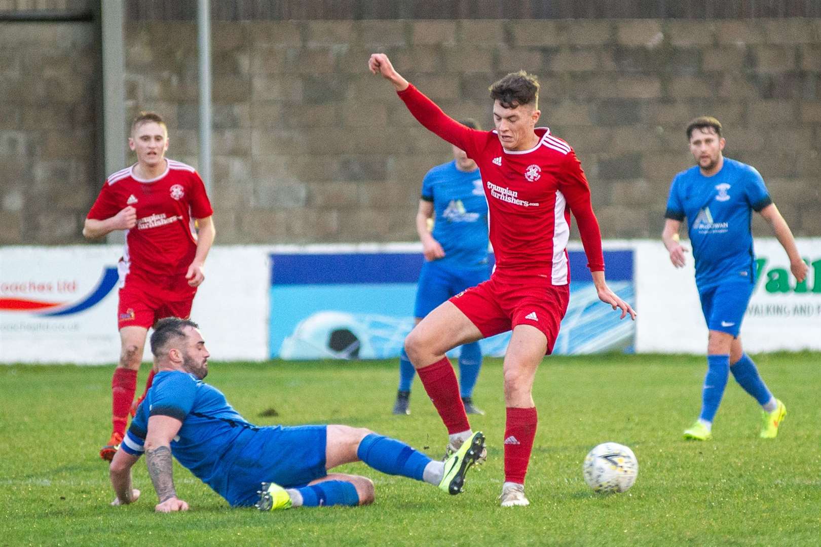 Strathspey Thistle captain James Fraser slides in to win the ball off Lossiemouth's Brodie Allen during a 2-0 win for the Jags away at Grant Park. The game in January, last year, turned out to be one of the last before the Covid pandemic struck. Picture: Daniel Forsyth