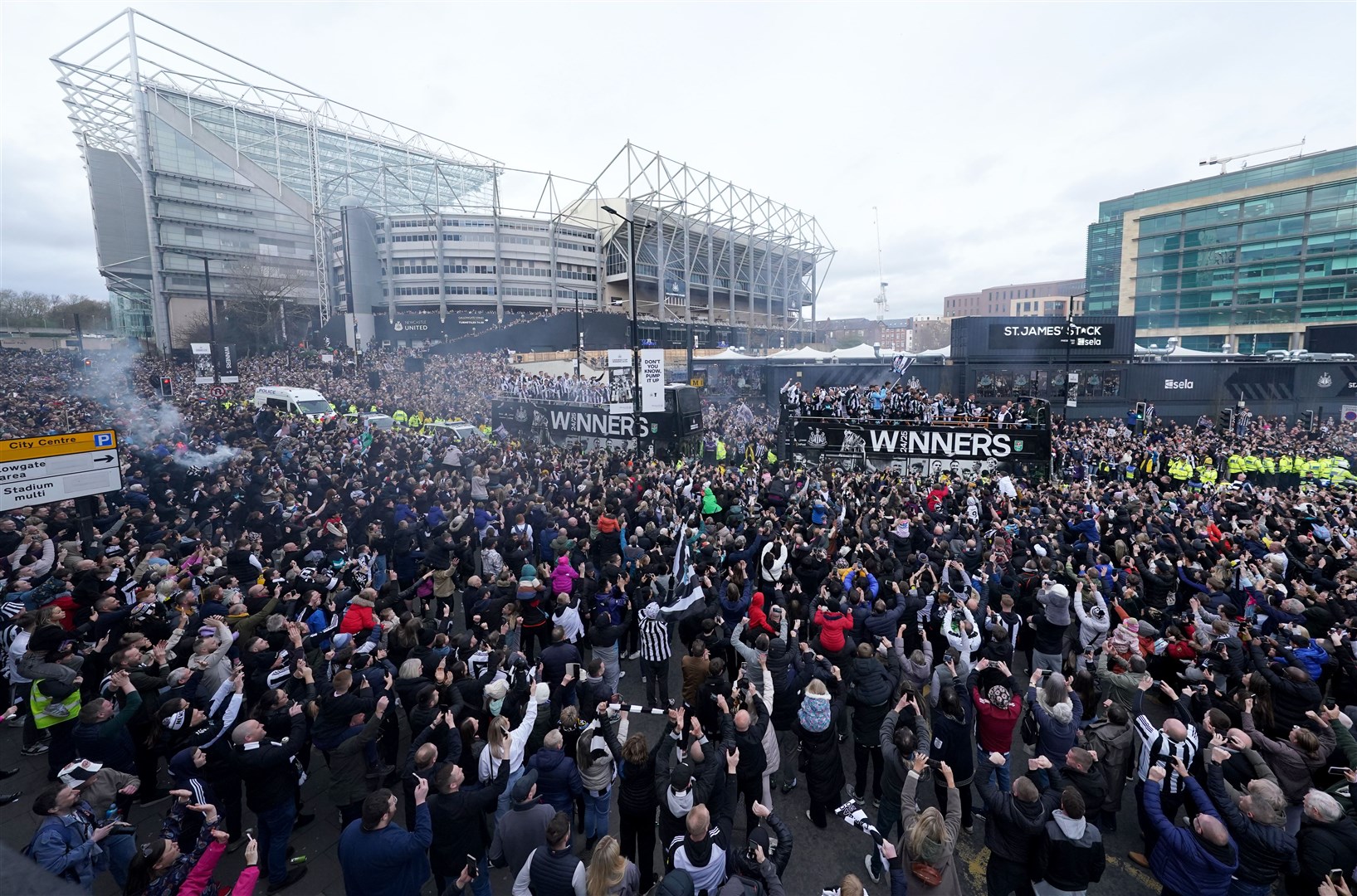 The open top buses carrying the Newcastle United players pass by fans outside St James’ Park during the Carabao Cup trophy parade in Newcastle (Owen Humphreys/PA)
