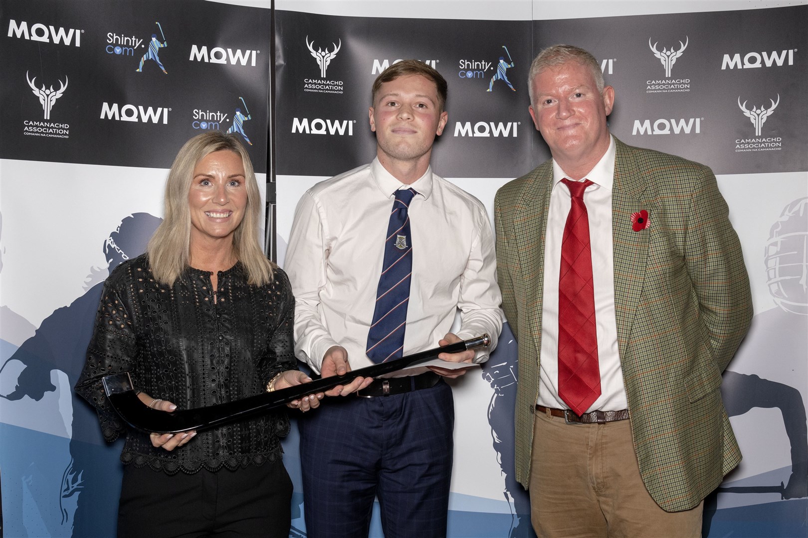 Mowi Player of the Year (Premiership & National) Roddy Young of Kingussie, is presented with the honour by Mowi's Jayne Mackay and Dougie Hunter (right) at the Mowi Shinty Awards 2022.