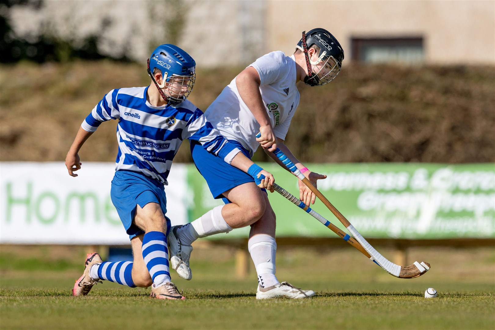 Newtonmore's Rory Gilligan stays close to Seth Macdonald (Skye).