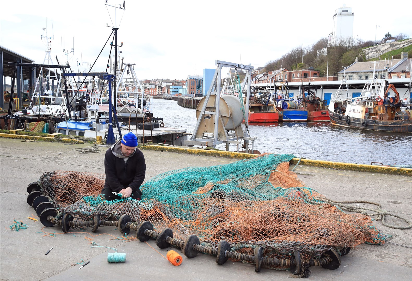 A fisherman repairs nets at North Shields Fish Quay (Owen Humphreys/PA)