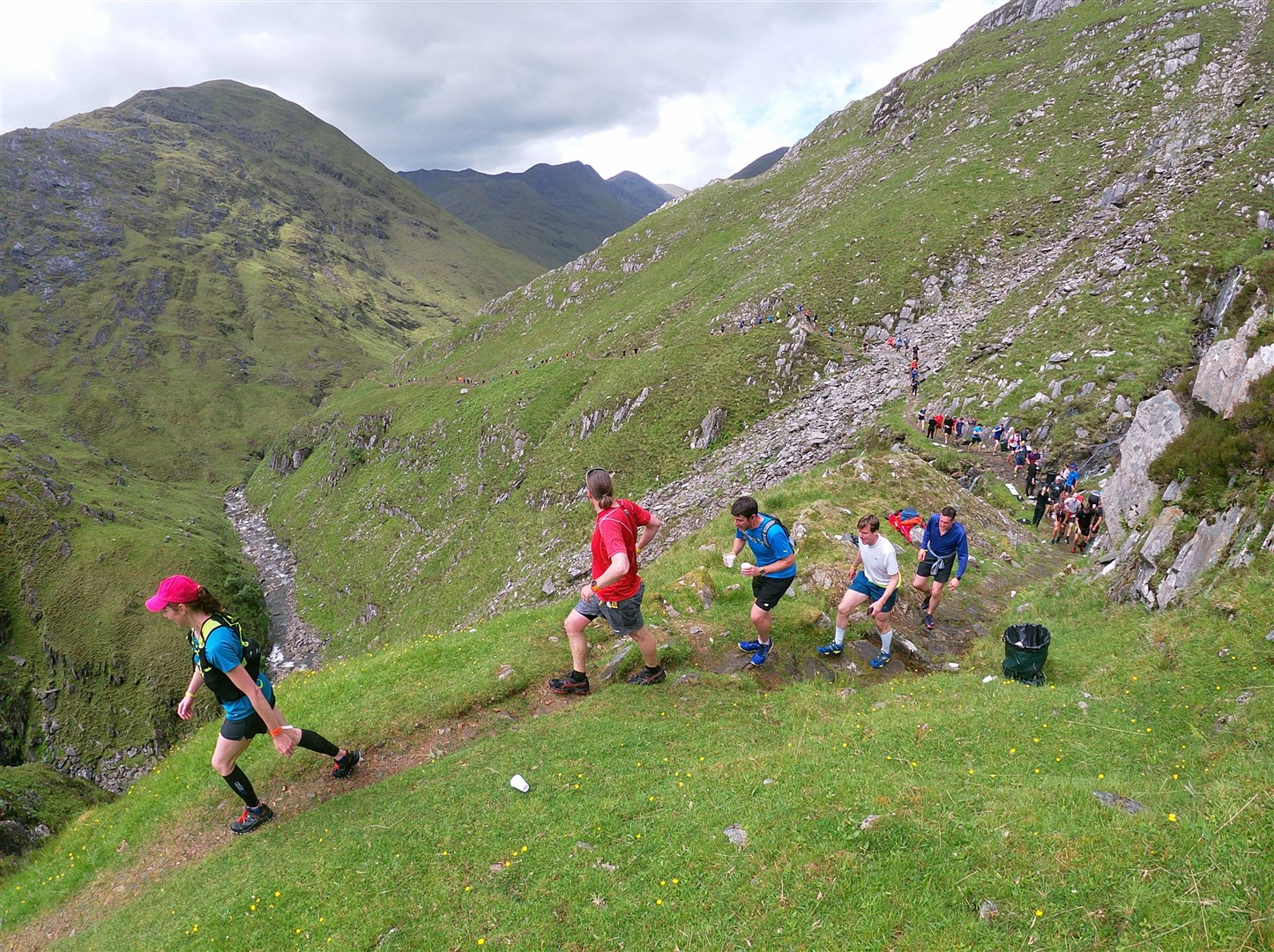 Runners pass the dramatic waterfall section on the Highland Cross route in Kintail.