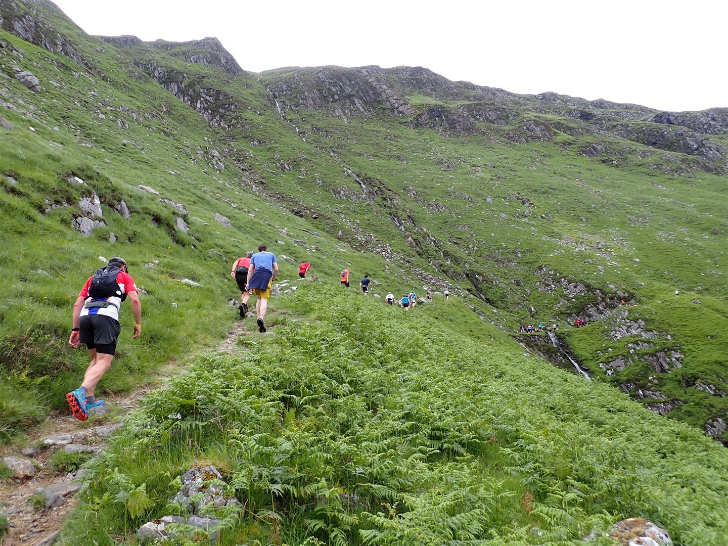 Runners make their way past the waterfall and up to the top of the hill.