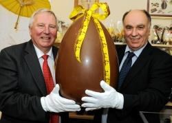 BID manager Mike Smith (left) and ARCHIE appeal chairman David Sutherland with the giant chocolate Easter egg which will be raffled in aid of the refurbishment of the children’s ward at Raigmore Hospital.