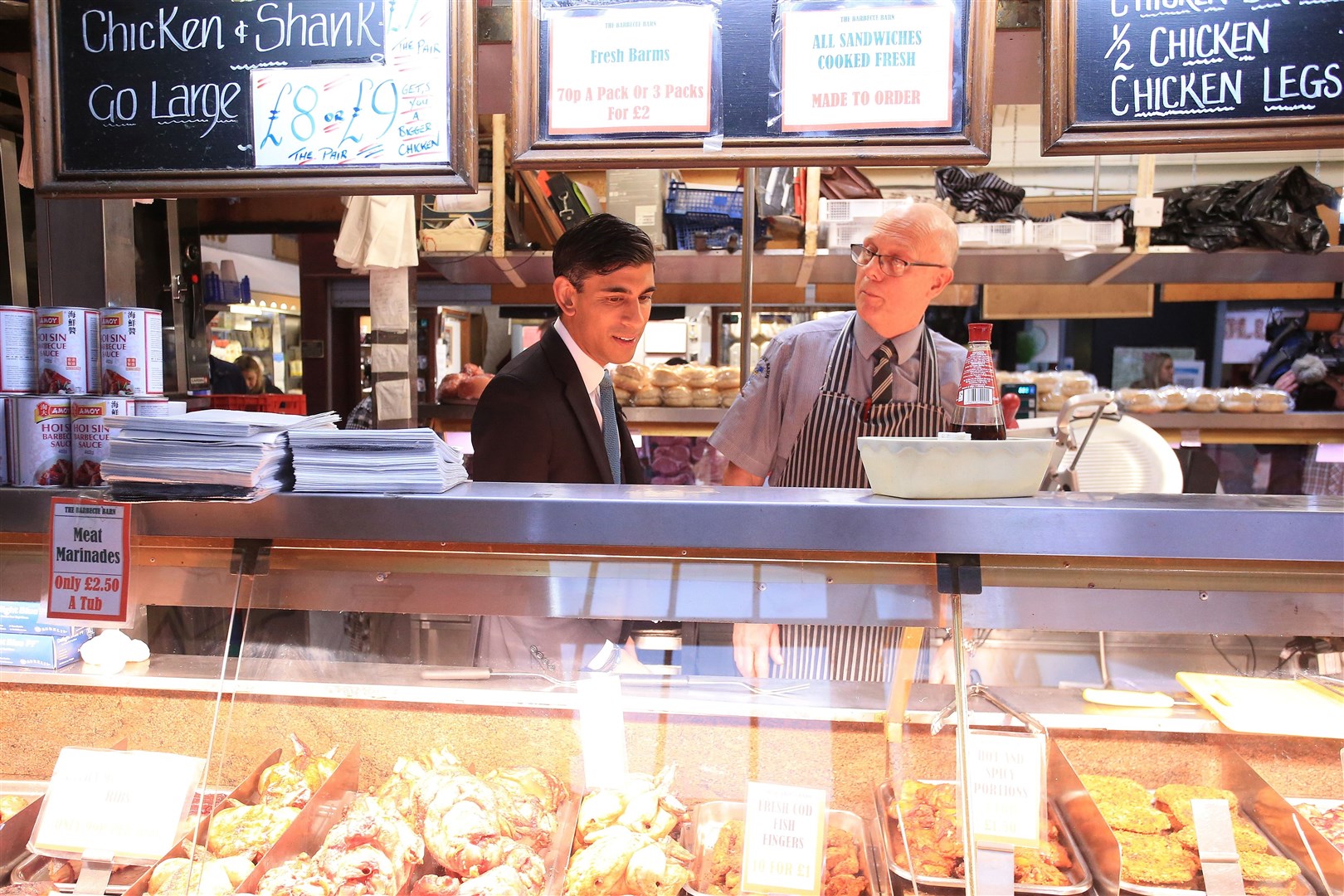 Chancellor Rishi Sunak speaks to a butcher during a visit to Bury market in Lancashire (Lindsey Parnaby/PA)