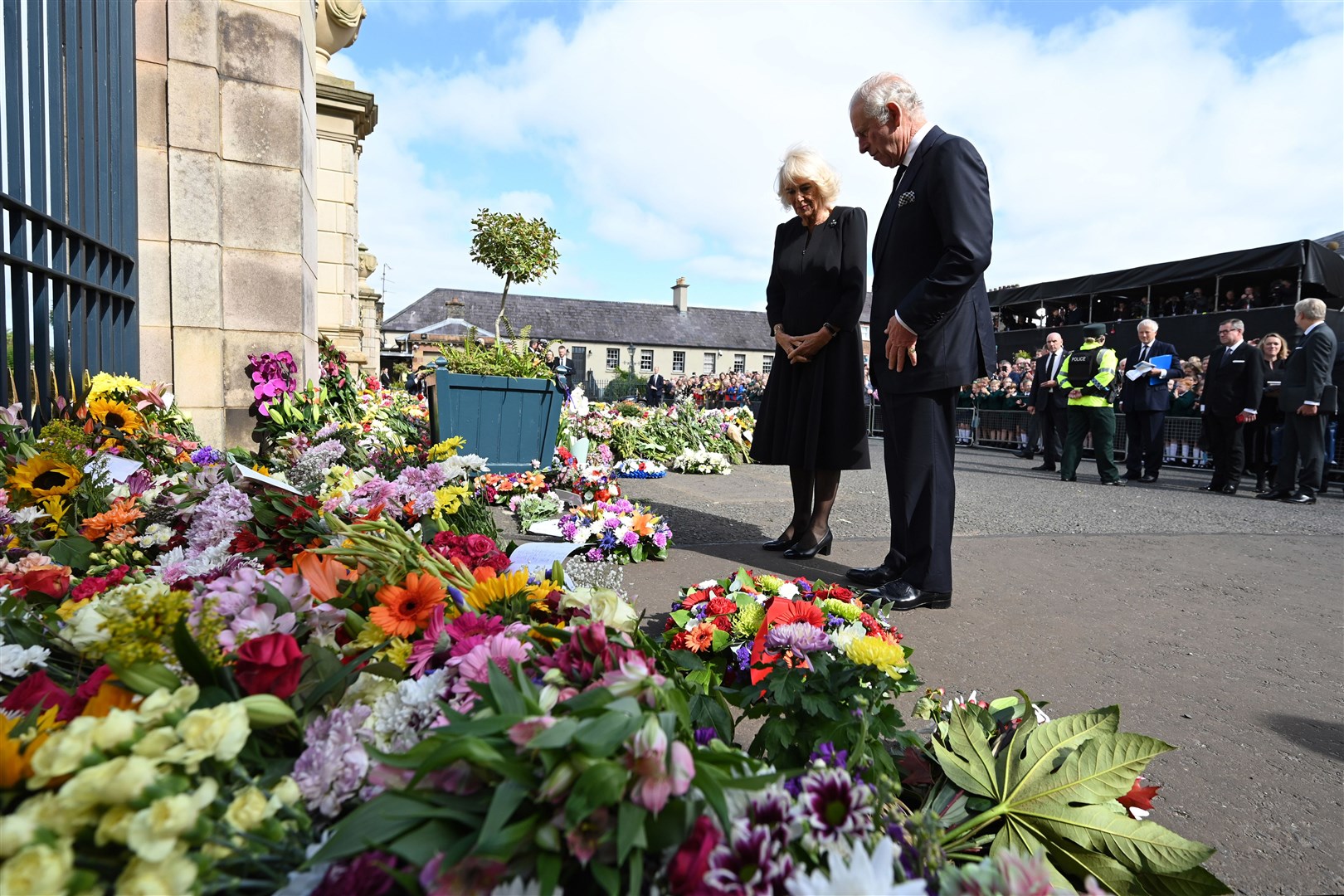 The King and Queen Consort were able to look at floral tributes left at Hillsborough Castle in Northern Ireland in the dry on Tuesday (Michael Cooper/PA)