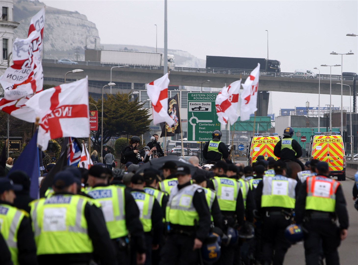 Police officers march with far-right protesters though Dover in Kent as they demonstrate against the arrival of immigrants in 2016