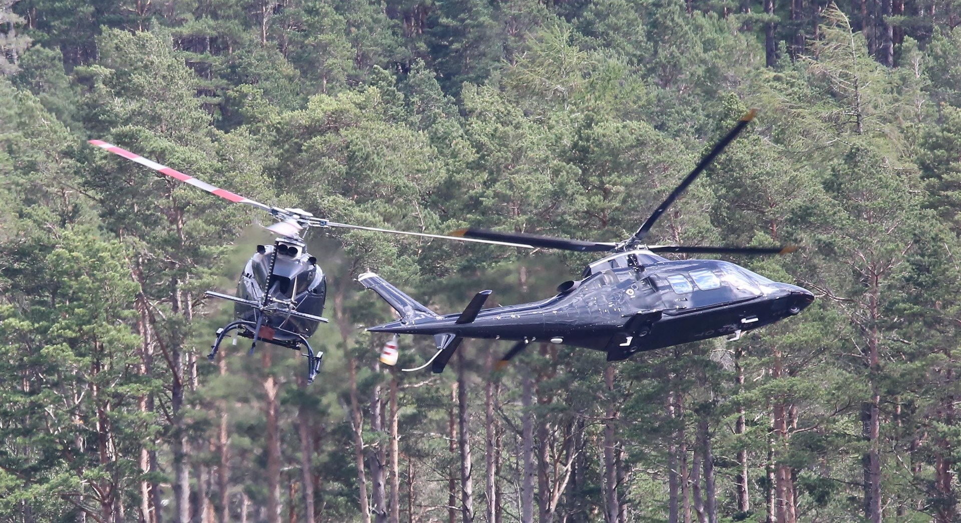 Helicopters filming above Loch Laggan three years ago. The helicopter on the left is filming the one on the right..(Photo: Peter Jolly)