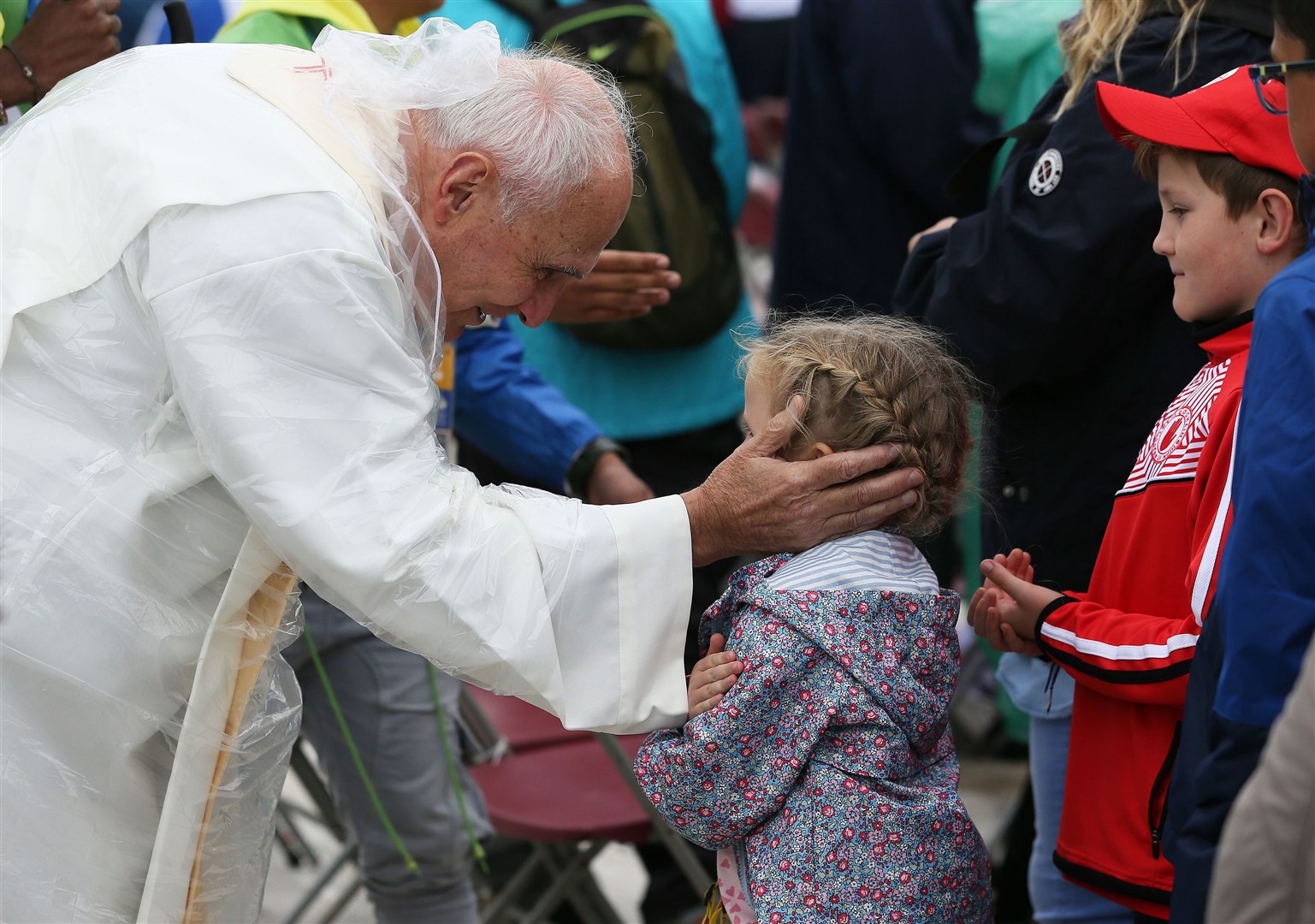 Francis blesses a young girl queuing for communion during the closing mass of his visit to Ireland at Dublin’s Phoenix park in August 2014 (PA)