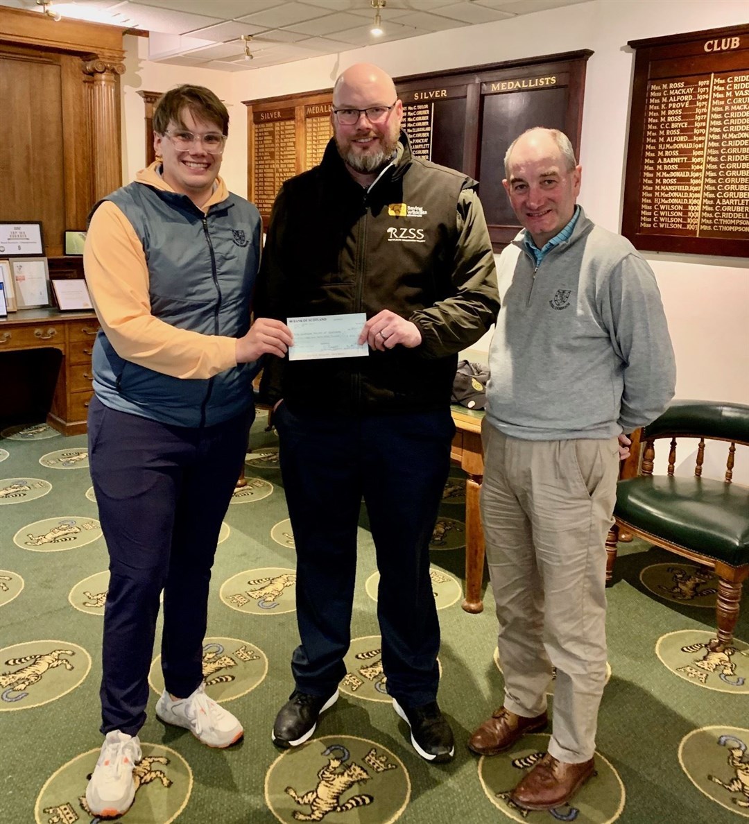 David Barclay (centre), ex-situ conservation manager with the Royal Zoological Society of Scotland, accepts an £854 cheque from Royal Dornoch Golf Club for the Saving Wildcats project from retail manager Brad Smith (left), with general manager Neil Hampton looking on.