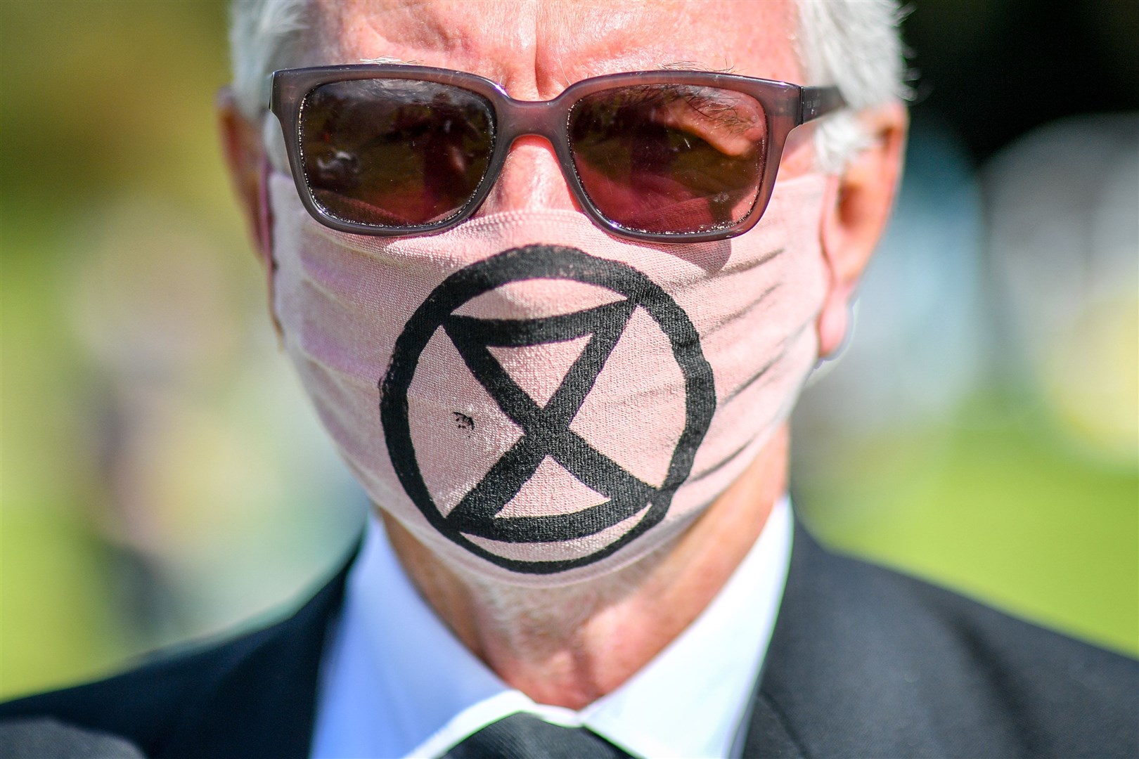 A man wears a mask with an Extinction Rebellion logo (Ben Birchall/PA)