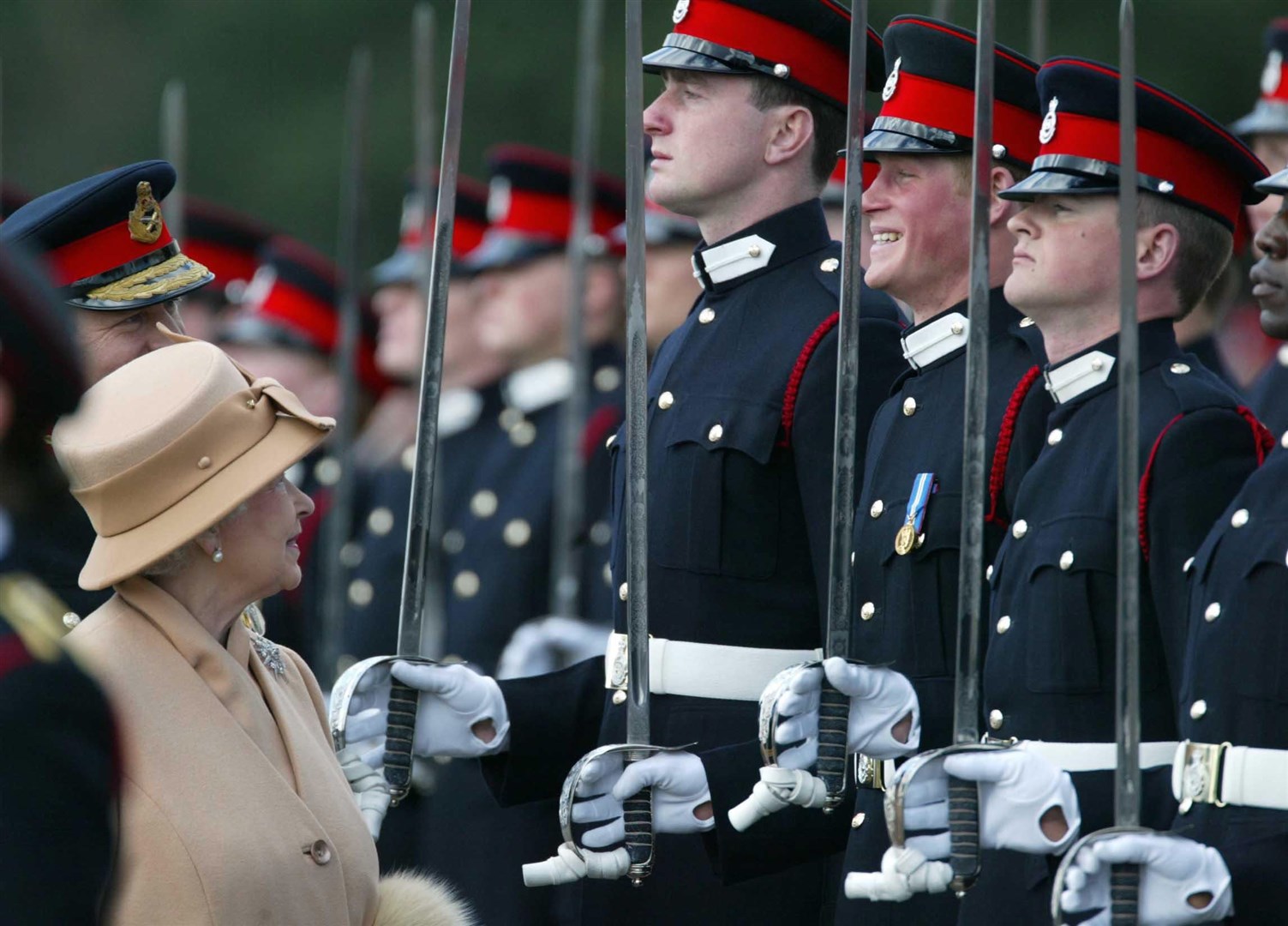 Prince Harry smiling broadly as his grandmother the Queen reviews him and other officers during The Sovereign’s Parade at Sandhurst in 2006 (James Vellacott/PA)