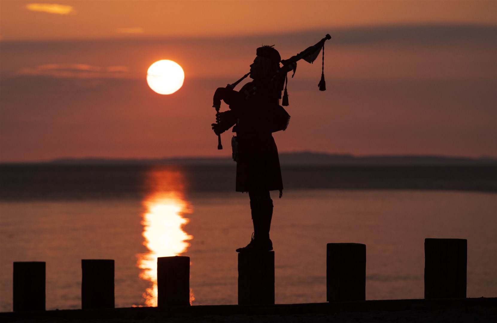 Piper Louise Marshall plays at dawn along Edinburgh’s Portobello Beach overlooking the Firth of Forth on the 75th anniversary of VE Day in May (Jane Barlow/PA)