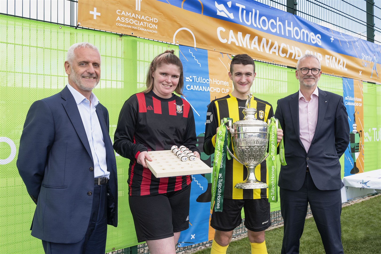 Sandy Grant (Tulloch Homes managing director) (left) and Innes Smith (Springfield Properties CEO) with festival shinty players who conducted the draw. Picture: Neil G Paterson