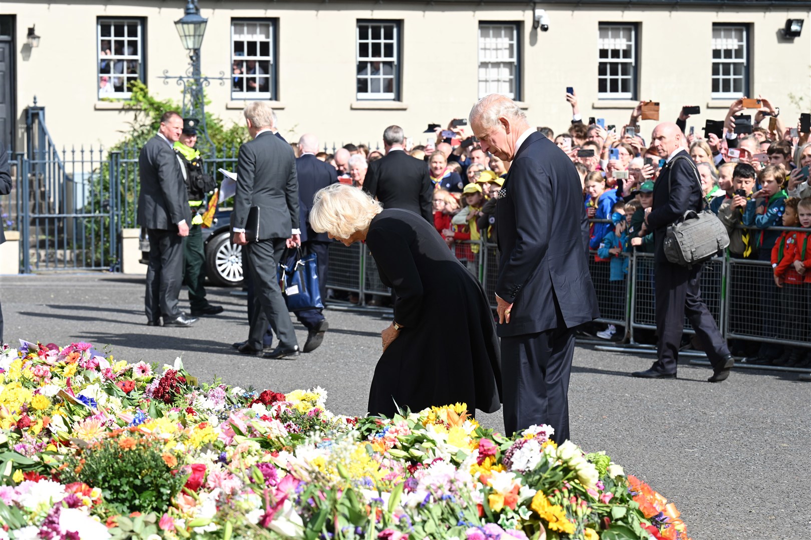 Charles and the Queen Consort look at floral tributes as they arrive at Hillsborough Castle (Michael Cooper/PA)