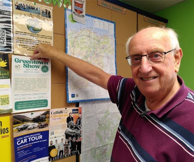 Peter Holland pins up a poster for Greentown 2024 in the Hub.