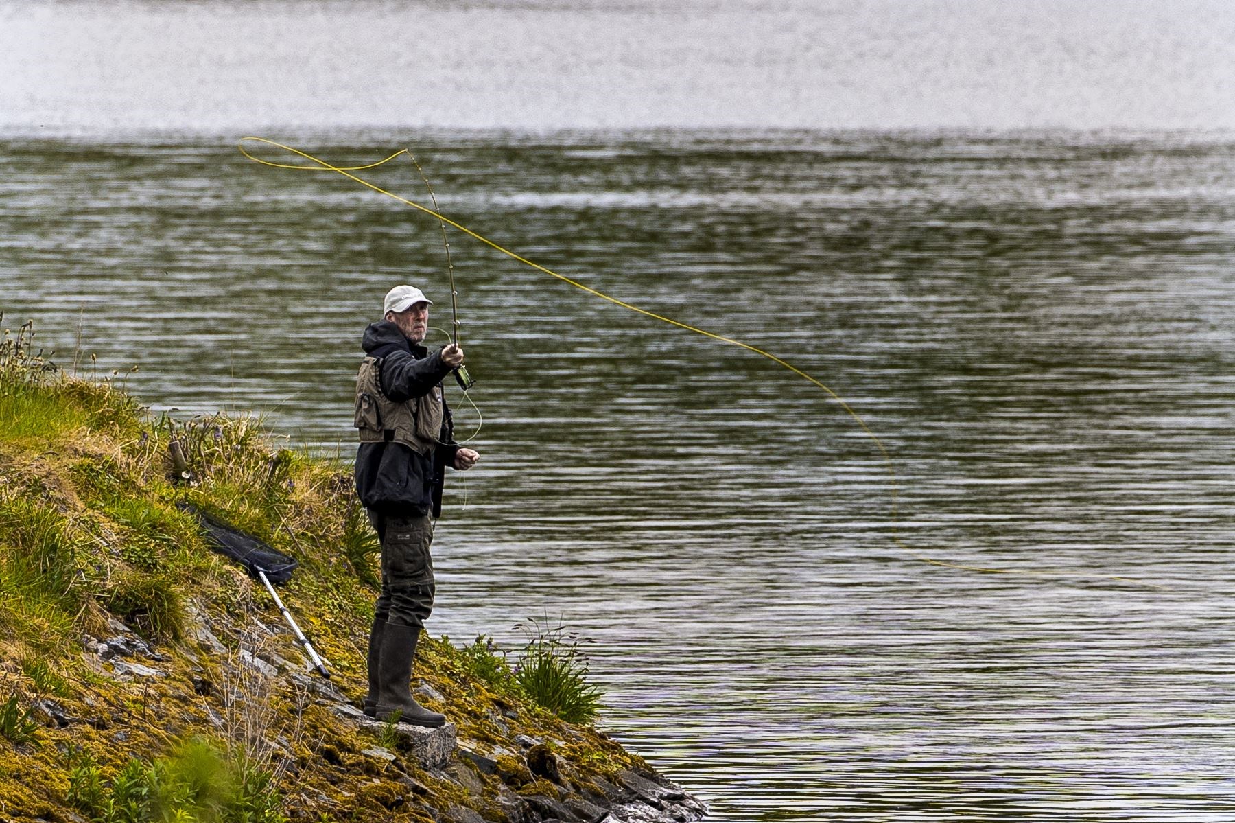 An angler fly fishing on the bank of Ballysallagh Lower Reservoir, as anglers were allowed to go fishing again in May as the lockdown eased (Liam McBurney/PA)