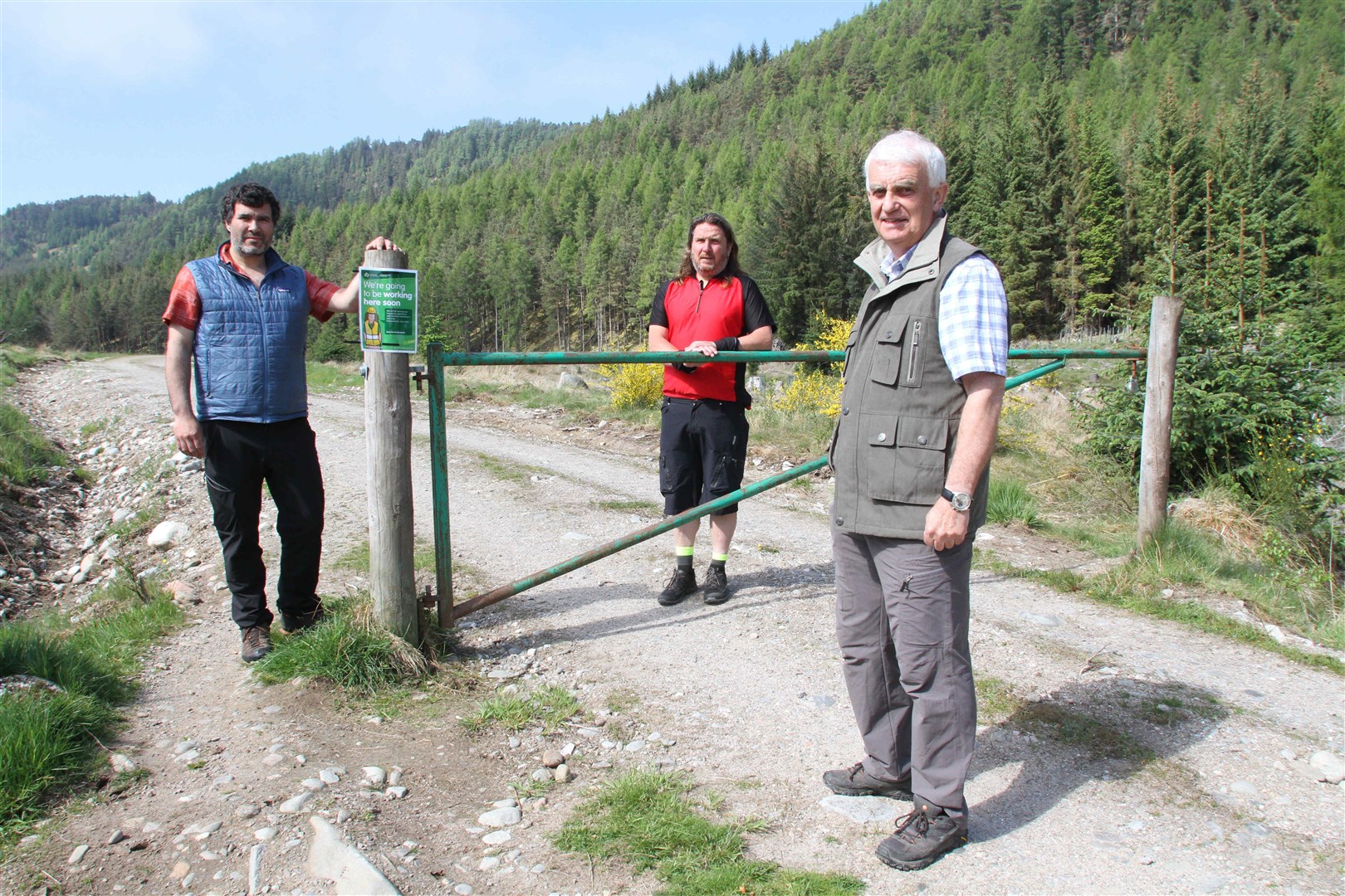 WAR PATH: Colin Morgan, chairman of Laggan Community Council (front) with Cristian Pizarro (left), the development officer at Laggan Forest Trust and local Highland councillor Russell Jones at the barrier on the path to the area's renowned Pictish fort. The signpost in the forest is the entrance to the site which will see significant disruption over the summer.
