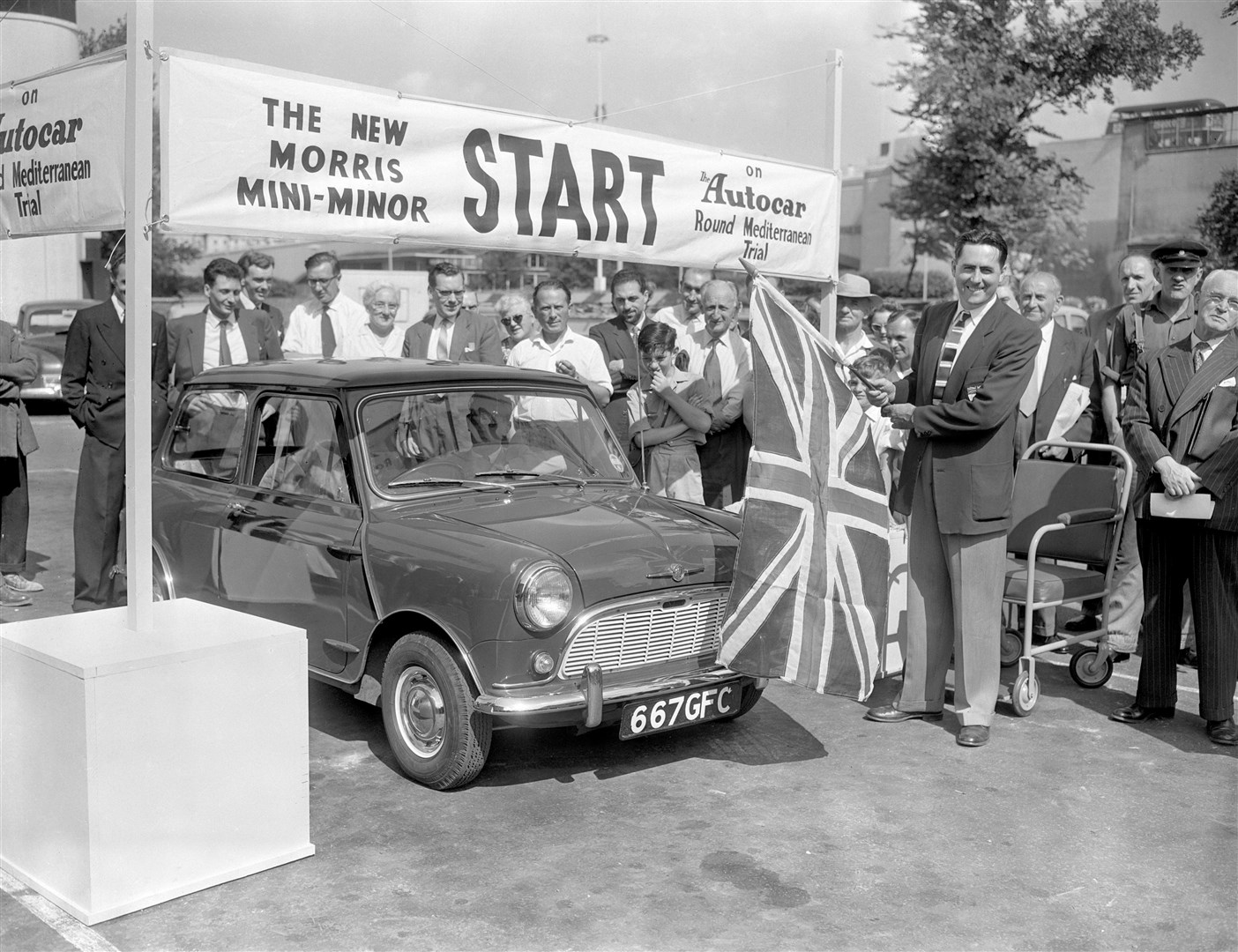 A new Morris Mini-Minor is waved off by Grand Prix star Jack Brabham on a trial run around the Mediterranean in 1959 (PA)