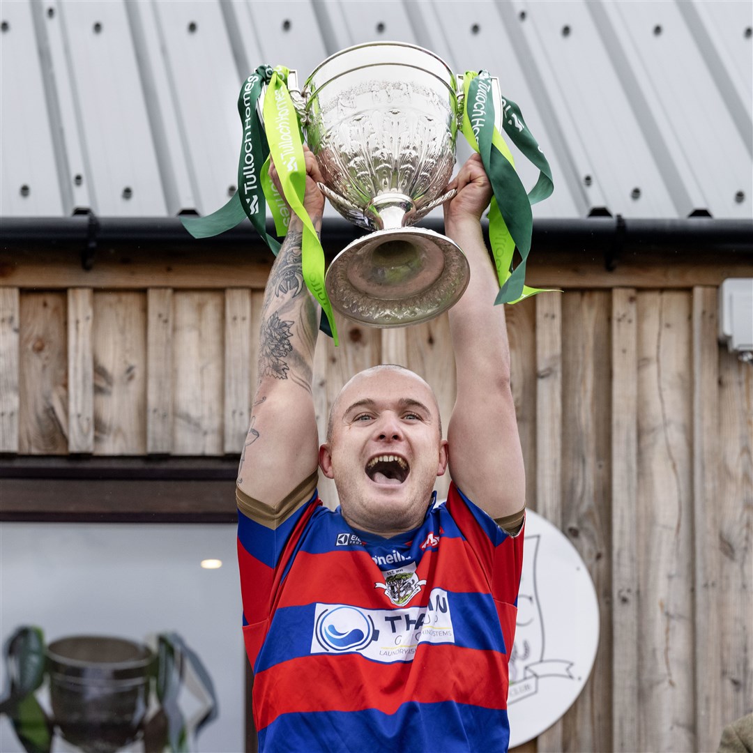 Kingussie captain Savio Genini lifts the Camanachd Cup this afternoon after a stunning game in which he opened the scoring. Photo: Neil Paterson.