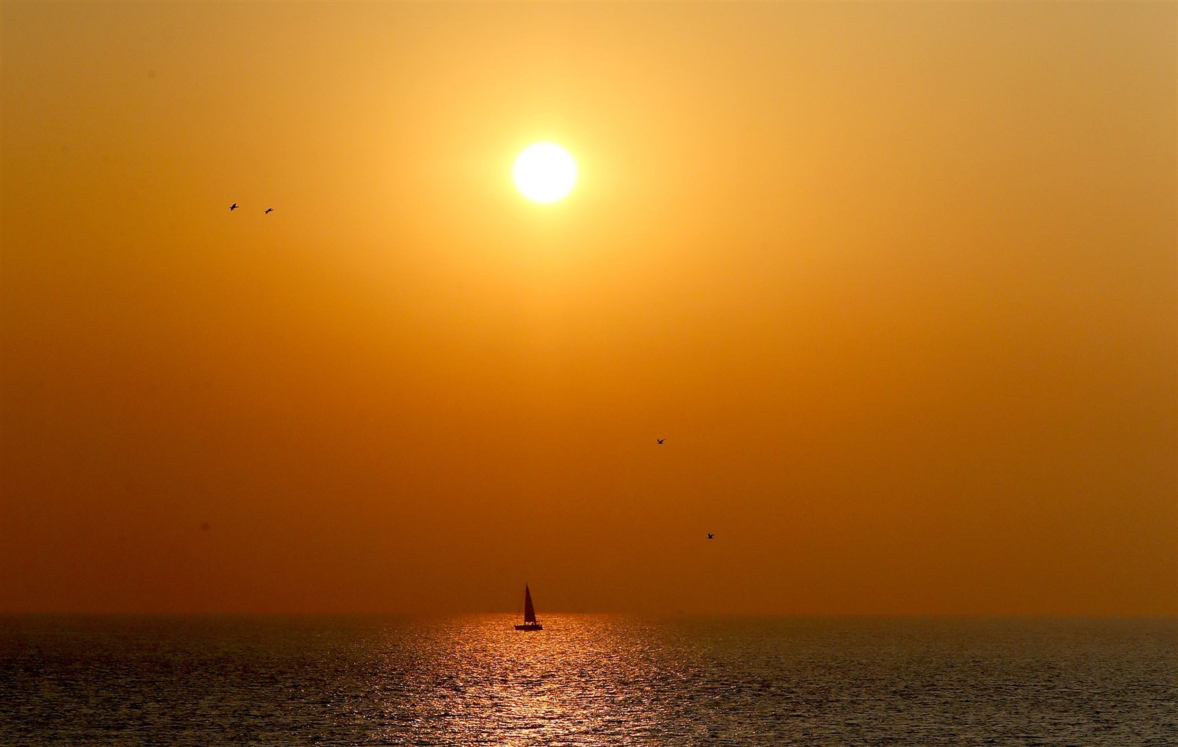 A yacht sails past St Margaret’s Bay at sunrise near Dover in Kent (Gareth Fuller/PA)