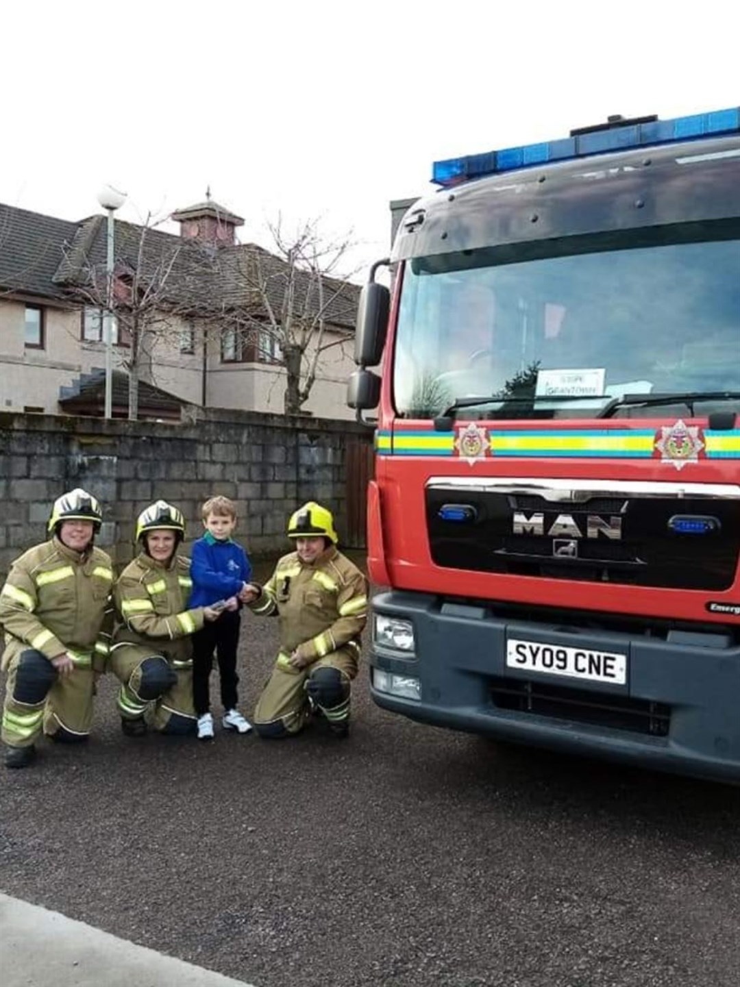 Reuben Timms accept Grantown fire crew's kind donation