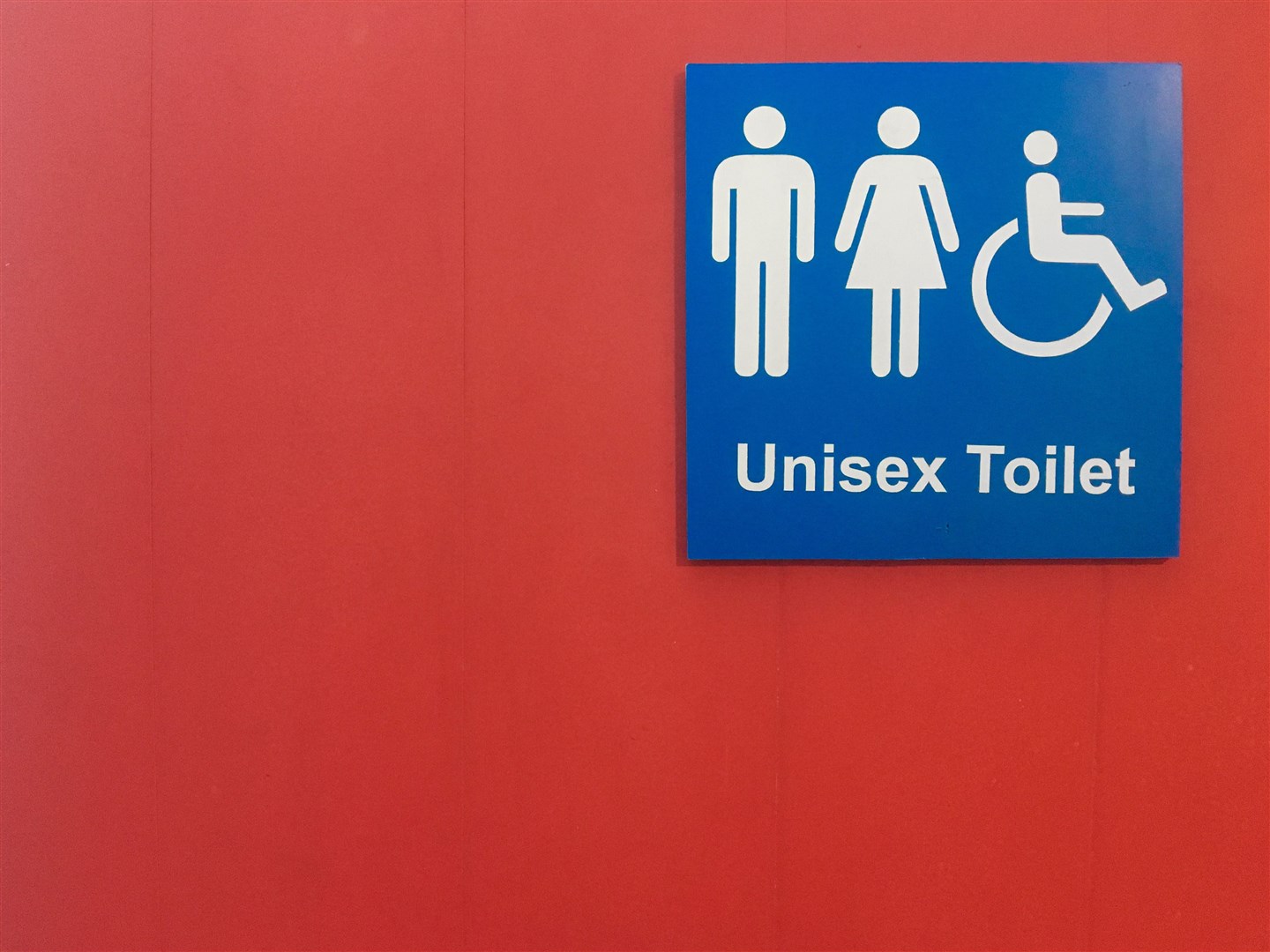 Blue label "unisex toilet" on red background