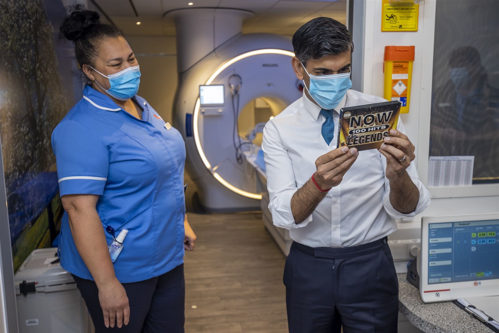 Rishi Sunak looks at a CD that is offered to patients while they have MRI scans during a visit to Oldham Community Diagnostic Centre (James Glossop/The Times/PA)