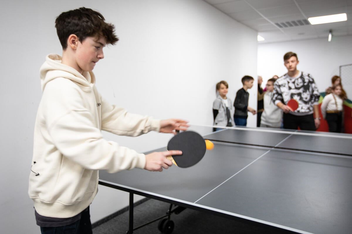 13-year-old Gabriel Clark playing ping pong with children in a school who have benefited from a fundraiser he set up (Save the Children)
