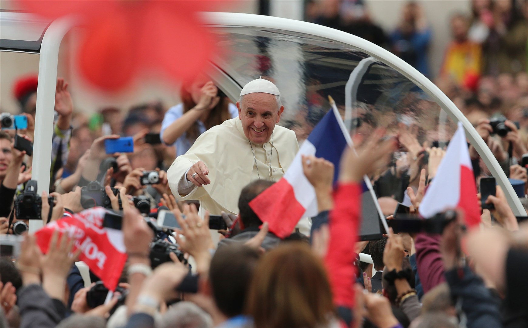 The Pope waves to the faithful in St Peter’s Square in Rome after the historic canonisation of Popes John XXIII and John Paul II in 2014 (Niall Carson/PA)