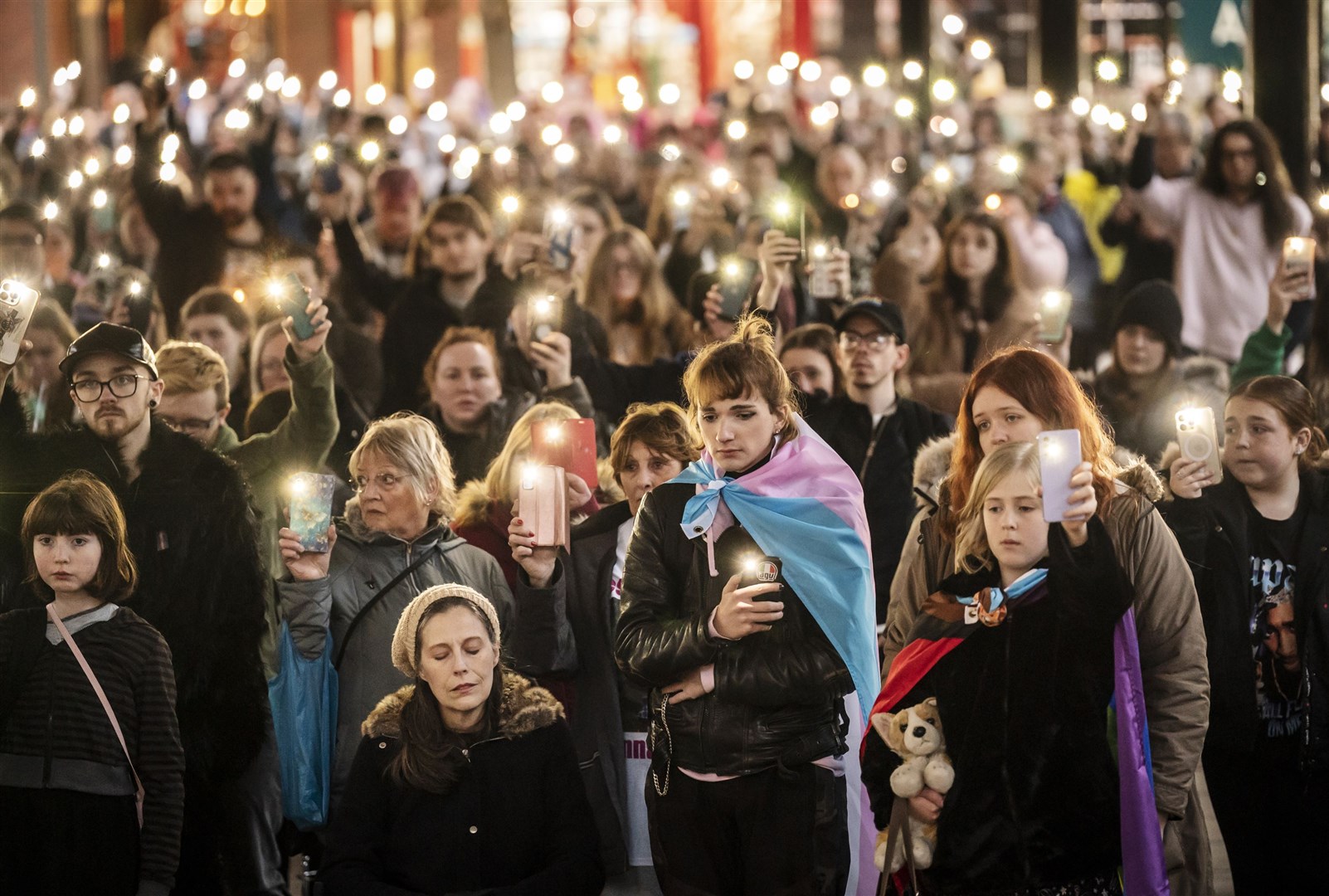 Members of the public hold their phones with the torch function set during a moment of silence as they attend a vigil for Brianna (PA)