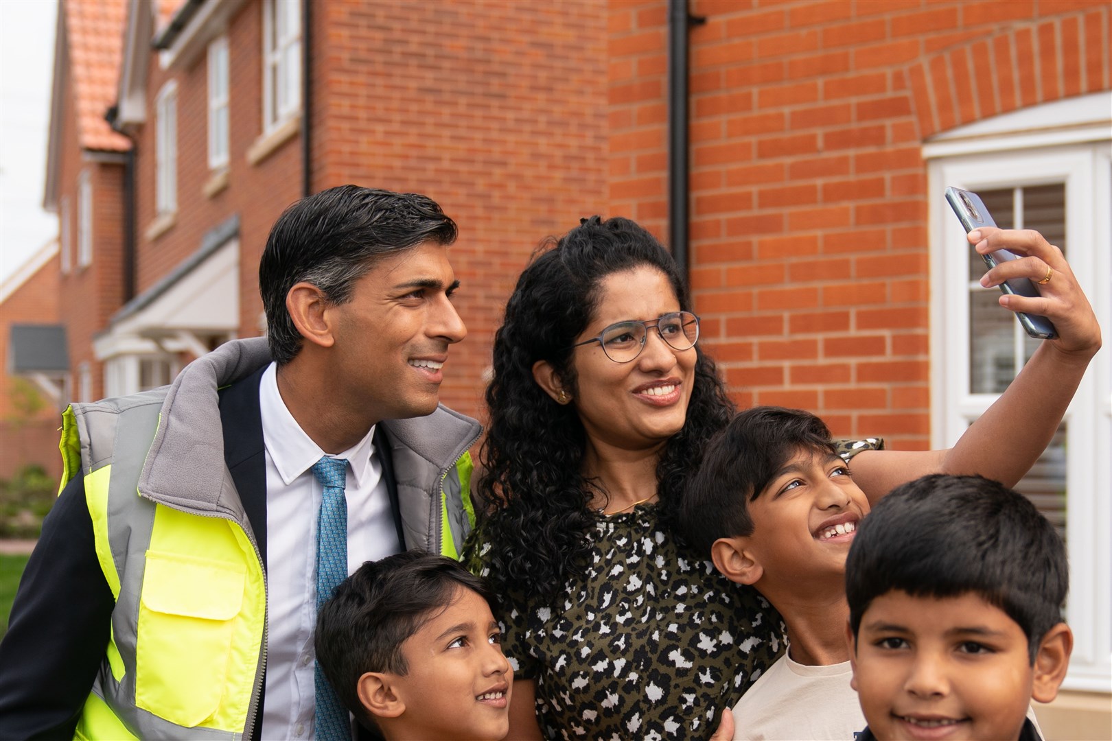 Prime Minister Rishi Sunak poses for a picture with the Mathew family during a visit to the Taylor Wimpey Heather Gardens housing development in Norwich (Joe Giddens/PA)