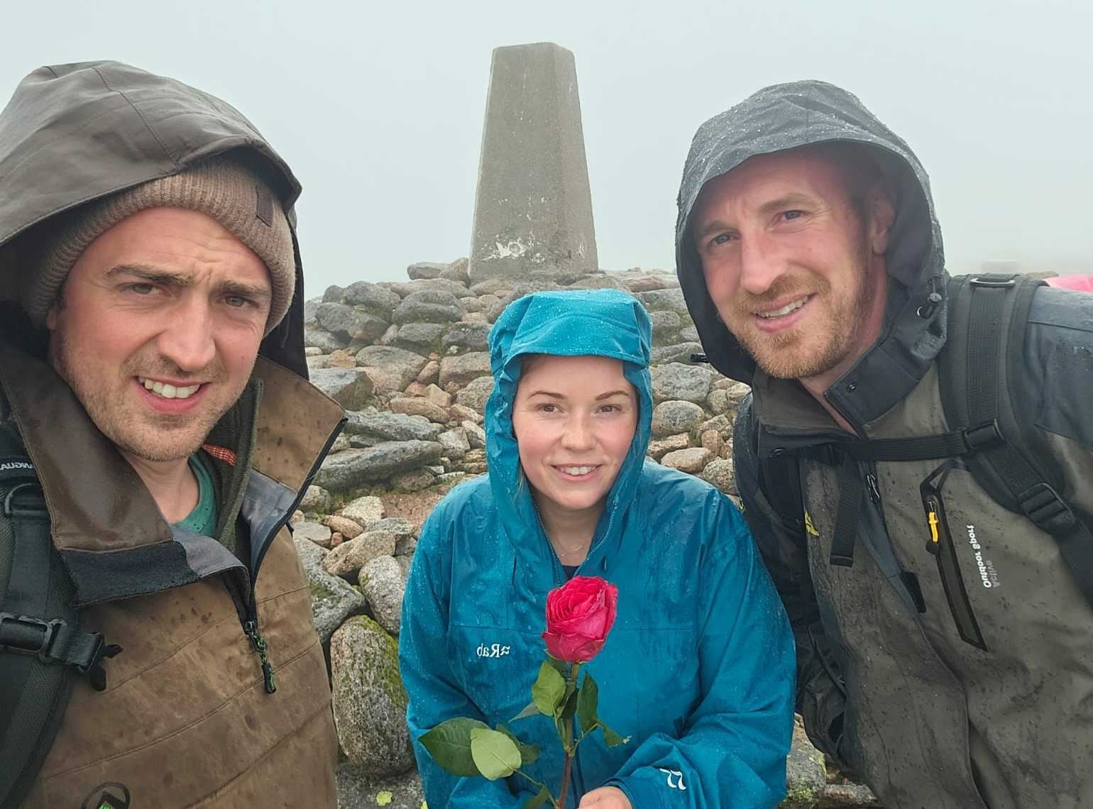 Still going strong despite the arrival of rain... Ben, Yasmin and Martin at the top of Ben Macdui after fighting through their sore feet. A rose - mum Caroline's favourite flower - was placed at each of the summits.