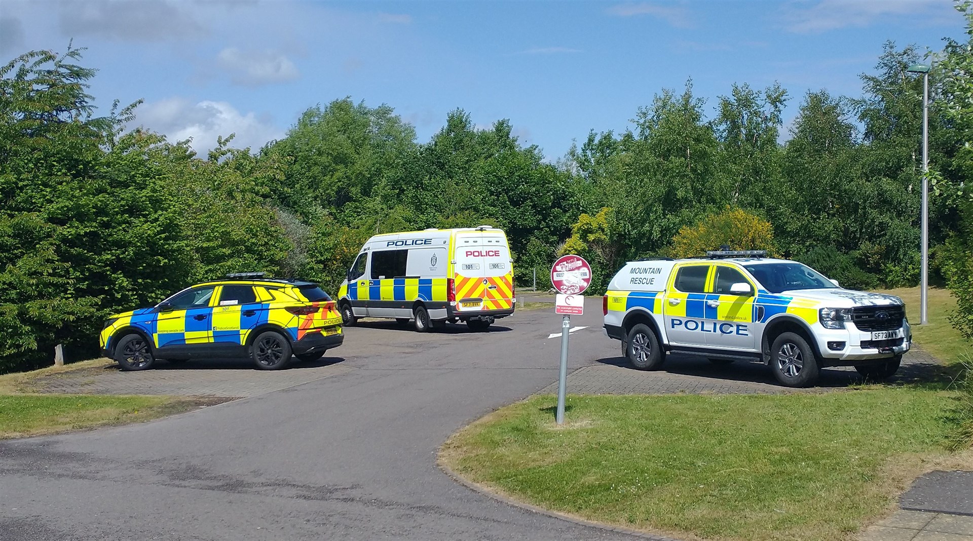 Police vehicles at a car park near Inshes Park.