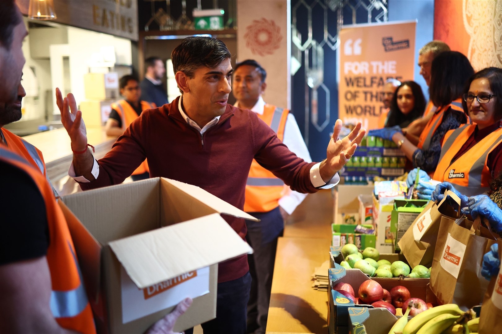 Rishi Sunak meets volunteers preparing food packages during a visit to a north London community centre (Henry Nicholls/PA)