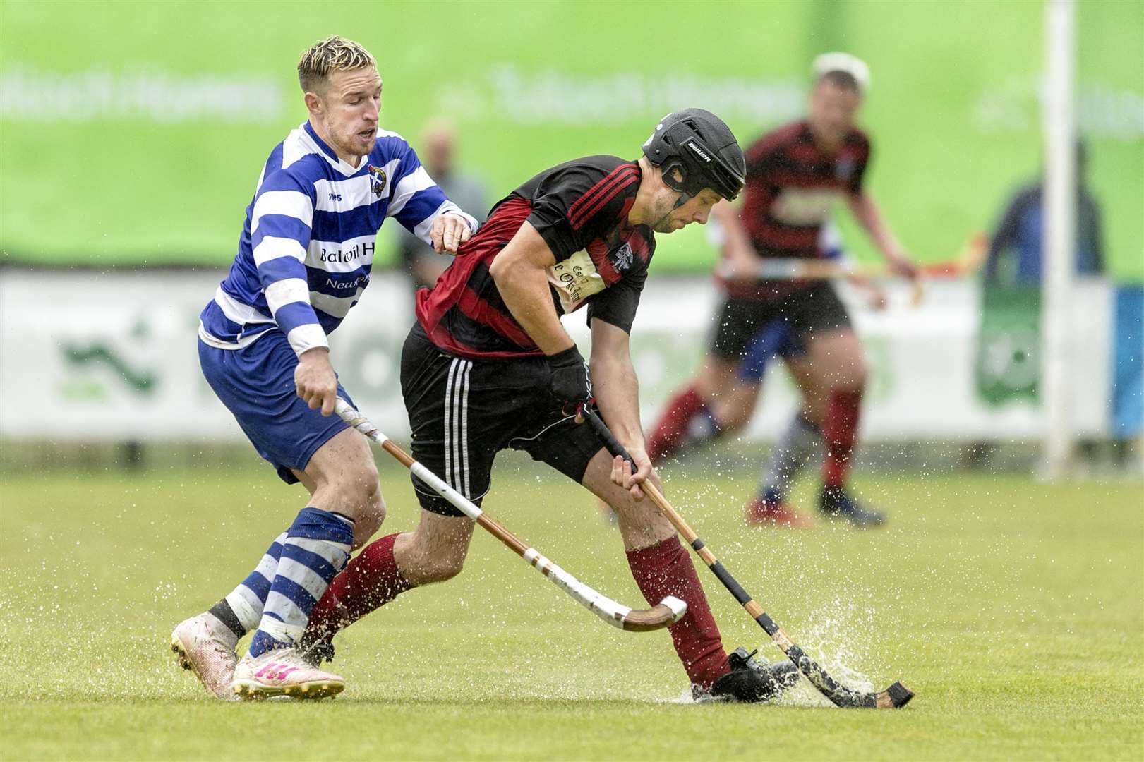 Andrew MacCuish (Oban) in front of Andy Mackintosh (N’more). Tulloch Homes Camanachd Cup Final - Newtonmore v Oban Camanachd - played at An Aird, Fort William.