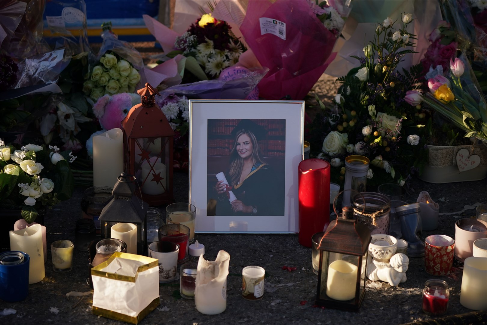 Floral tributes and candles surround a photograph left at the Grand Canal in Tullamore, Co Offaly, where primary school teacher Ashling Murphy was found dead (Niall Carson/PA)