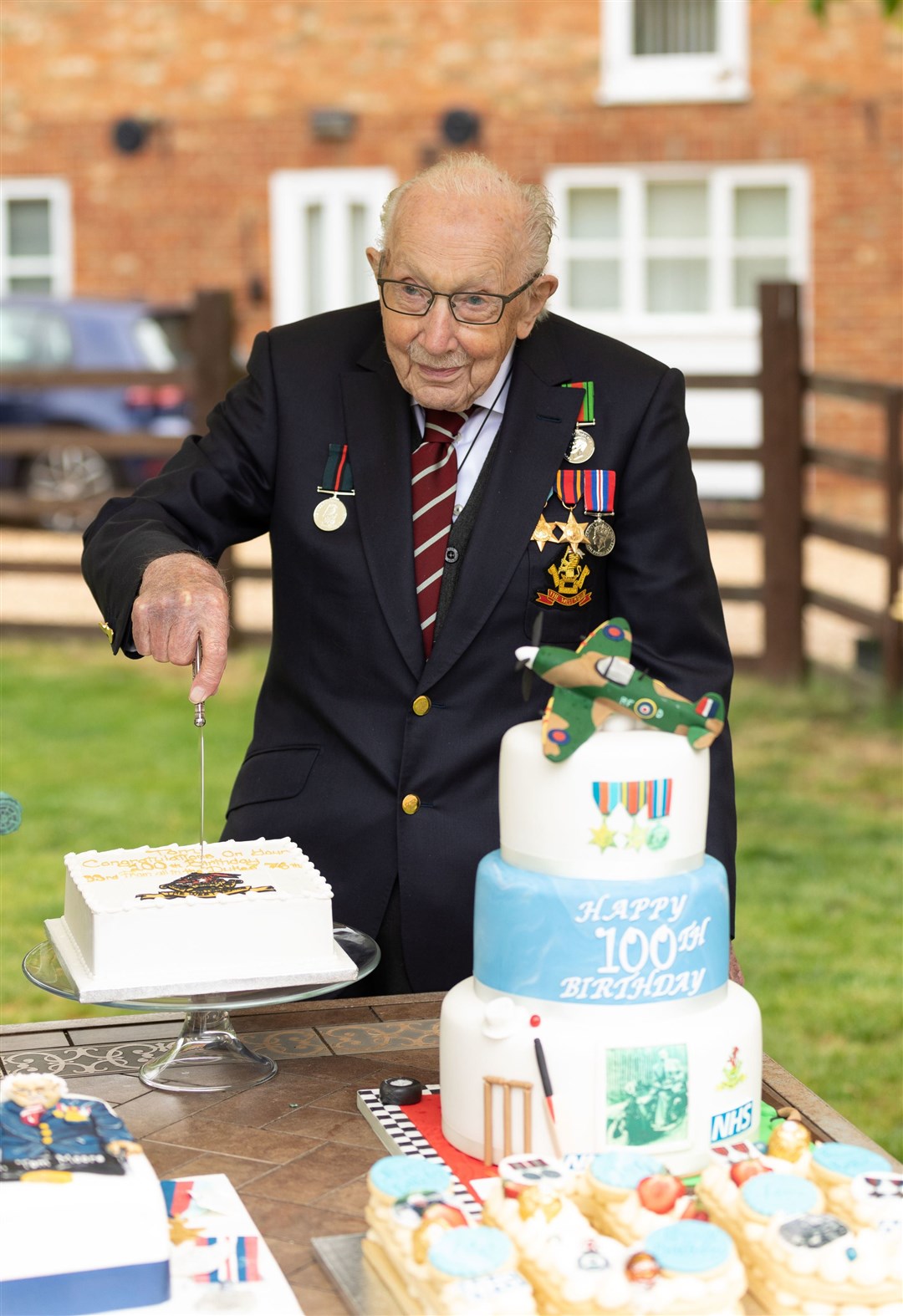 Second World War veteran Captain Tom Moore cutting a cake in the garden of his home in Maids Moreton as he celebrates his 100th birthday. Picture: Emma Sohl/Capture the Light Photography/PA Wire