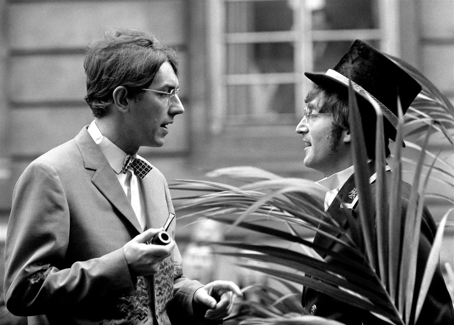 Comedian Peter Cook talking to John Lennon in 1966 (PA)