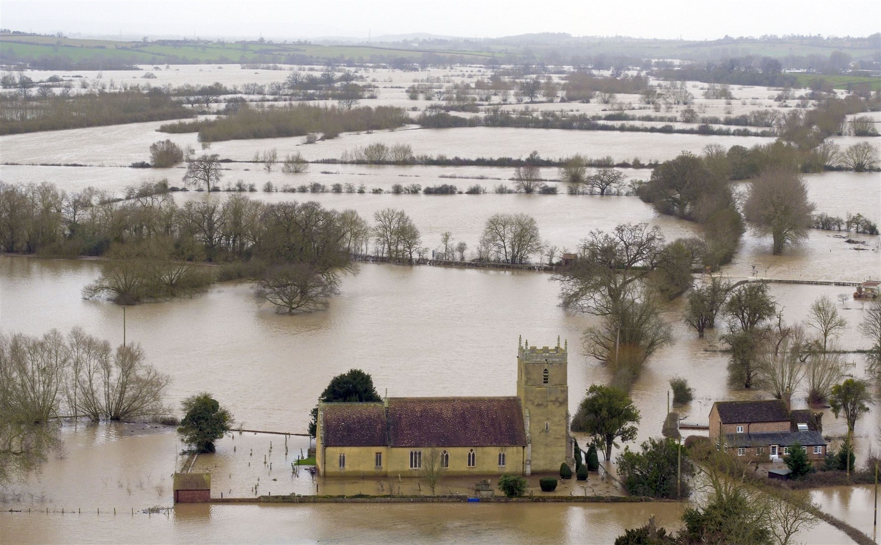 Flood water surrounding a church in Tirley, Gloucestershire