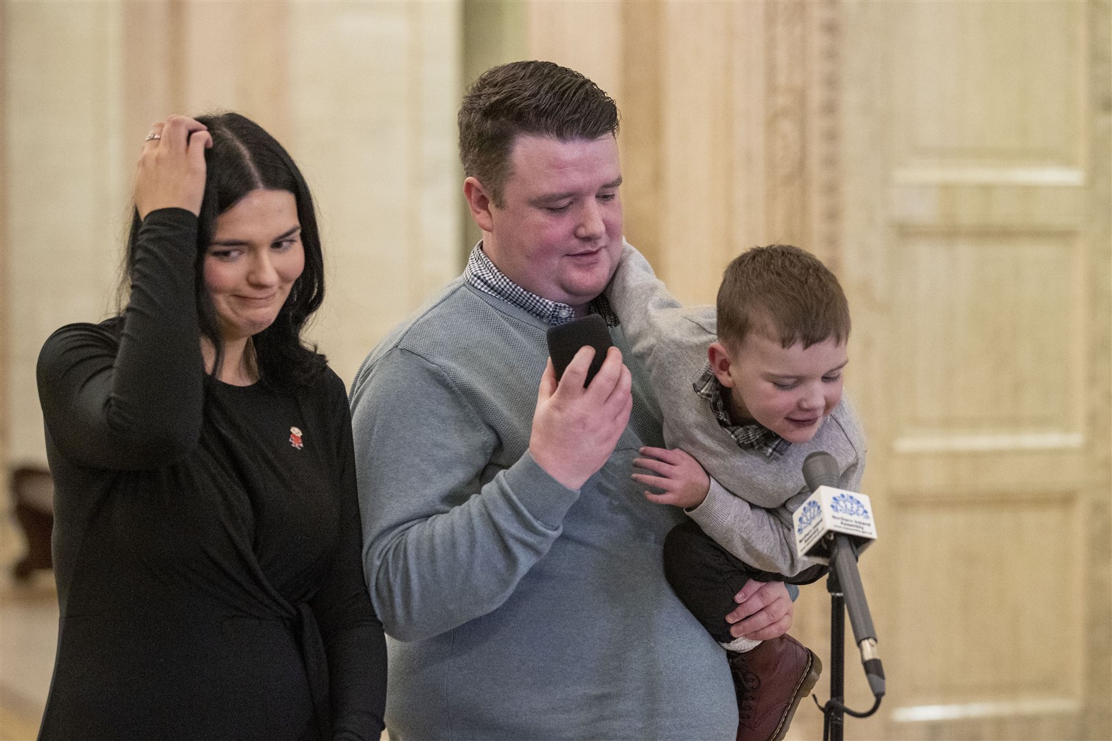 Daithi MacGabhann and his parents Mairtin MacGabhann and Seph Ni Mheallain at Parliament Buildings at Stormont (Liam McBurney/PA)