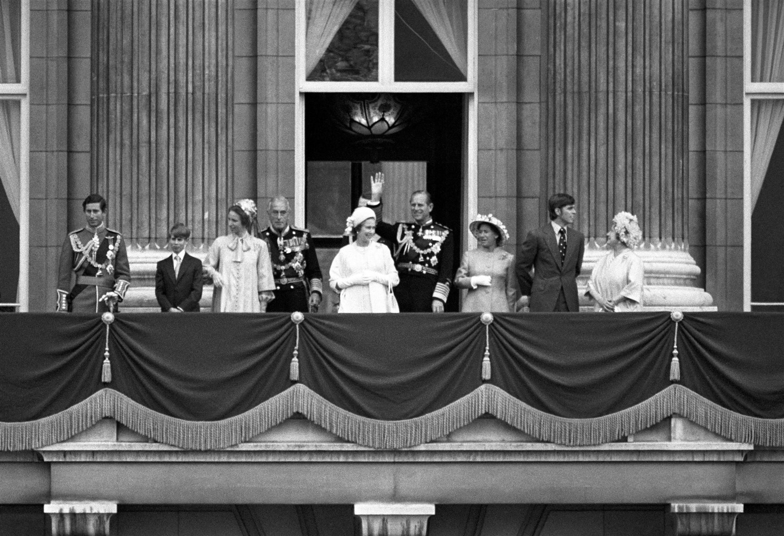 The Queen and Philip wave to crowds from the balcony with the Prince of Wales, Prince Edward, Princess Anne, Lord Mountbatten, Princess Margaret, Prince Andrew and the Queen Mother (PA)
