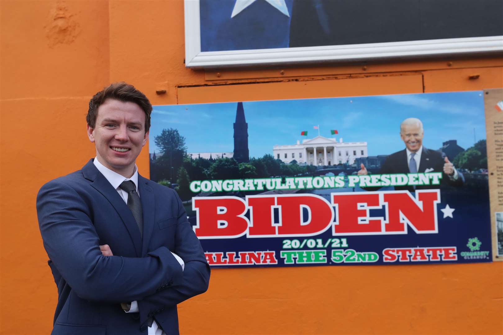 Mark Duffy, county councillor for Ballina, stands in front of a mural of Mr Biden (Niall Carson/PA)