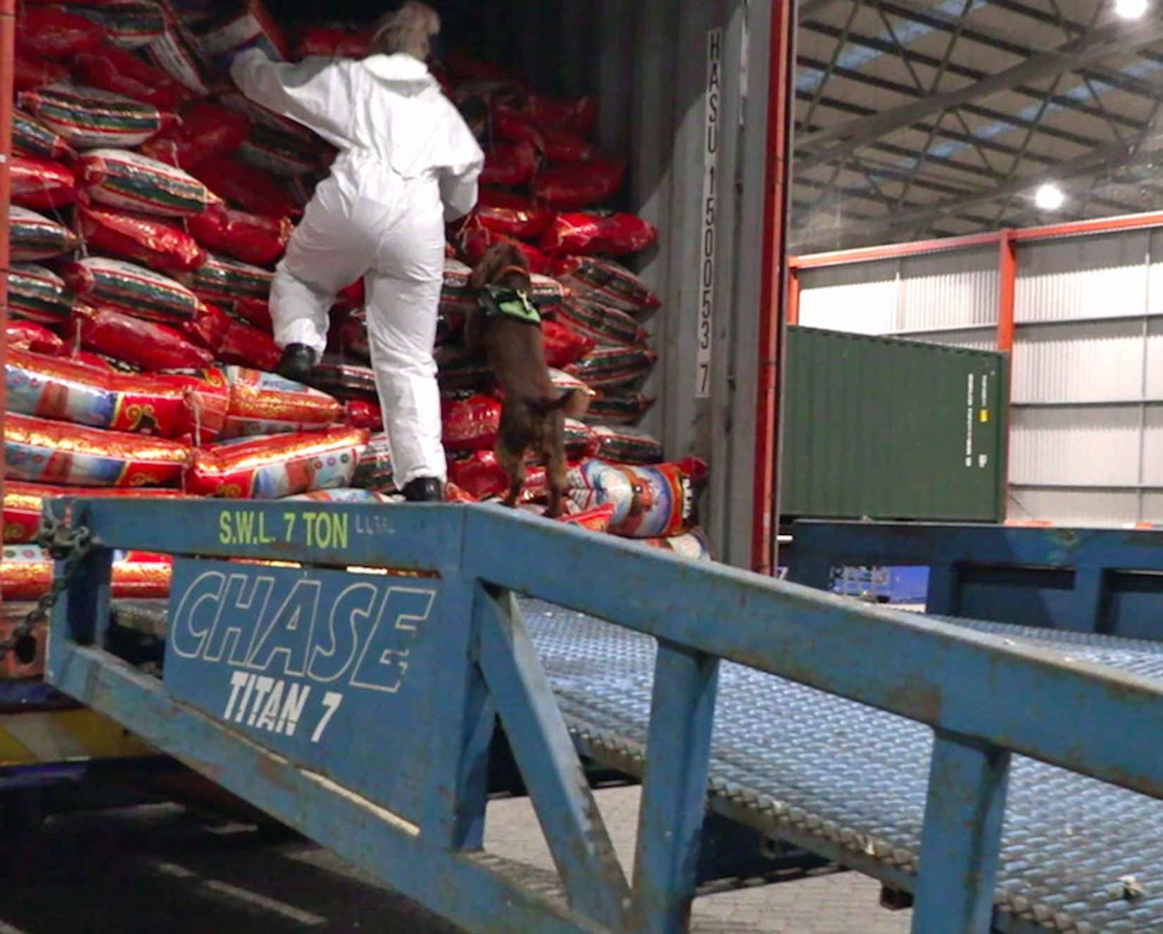 An officer unloads bags of rice which contained heroin at the port of Felixstowe (National Crime Agency/PA)