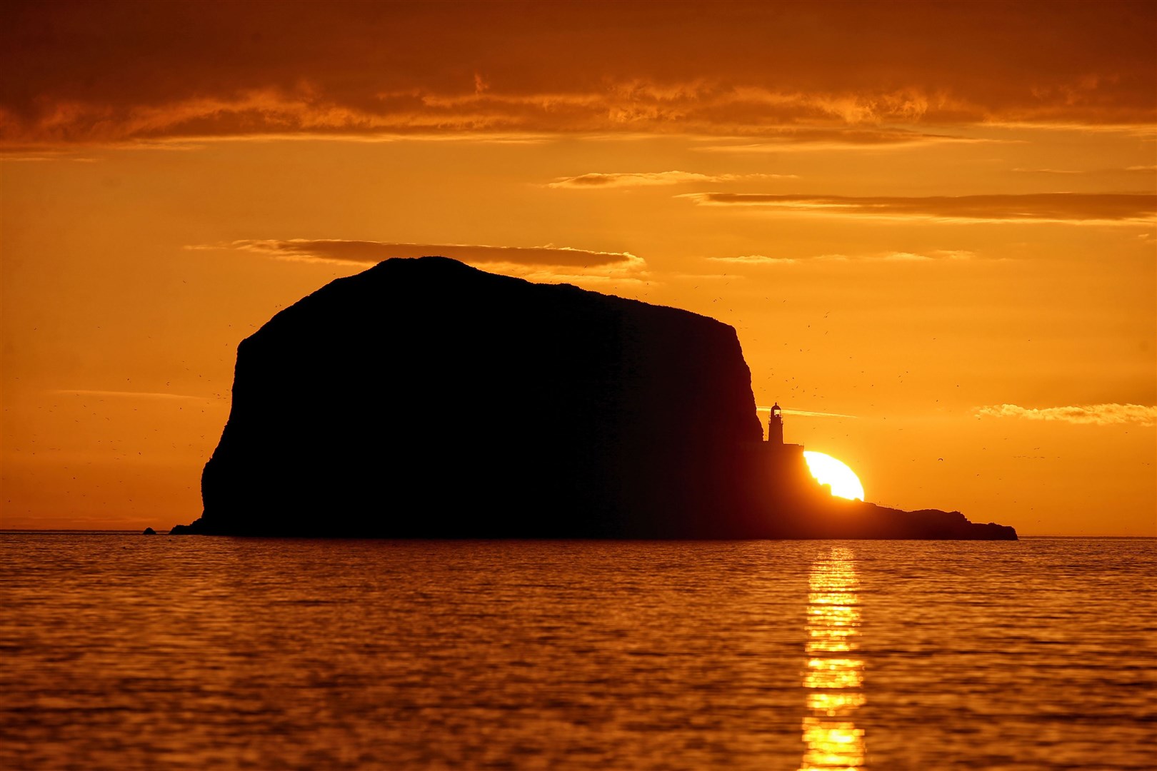 The sun rises over Bass Rock lighthouse in the Firth of Forth near North Berwick, East Lothian (Jane Barlow/PA)