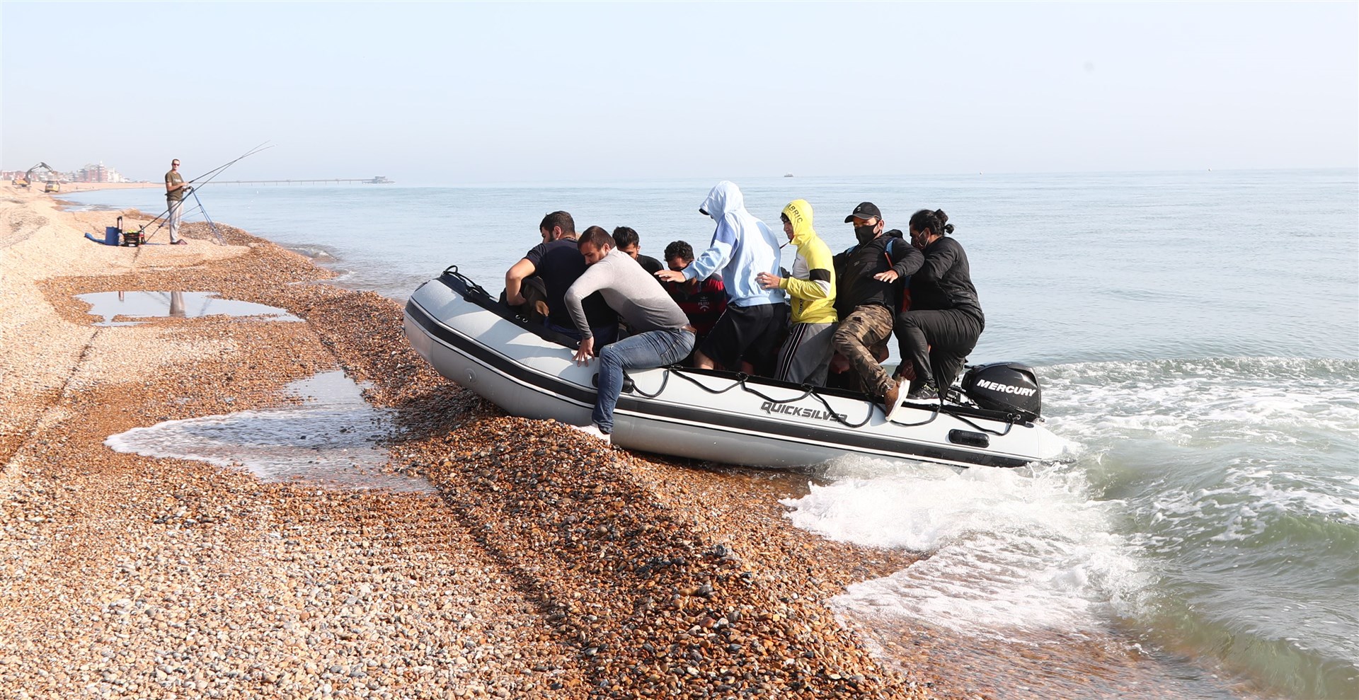 A group of people thought to be migrants arrive in an inflatable boat at Kingsdown beach, near Dover, Kent, after crossing the English Channel (Gareth Fuller/PA)