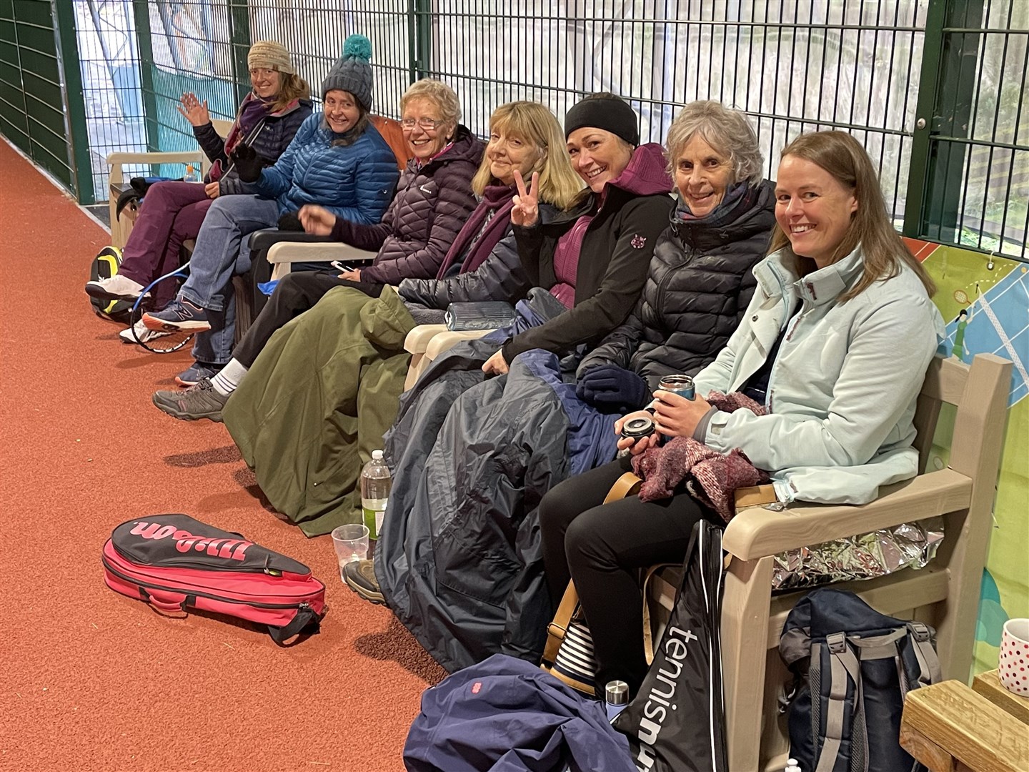 Players and spectators are wrapped up against the cold on Sunday afternoon in the covered court.