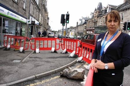 Louise Laing at the site showing part of the masonry and the area cordoned off
