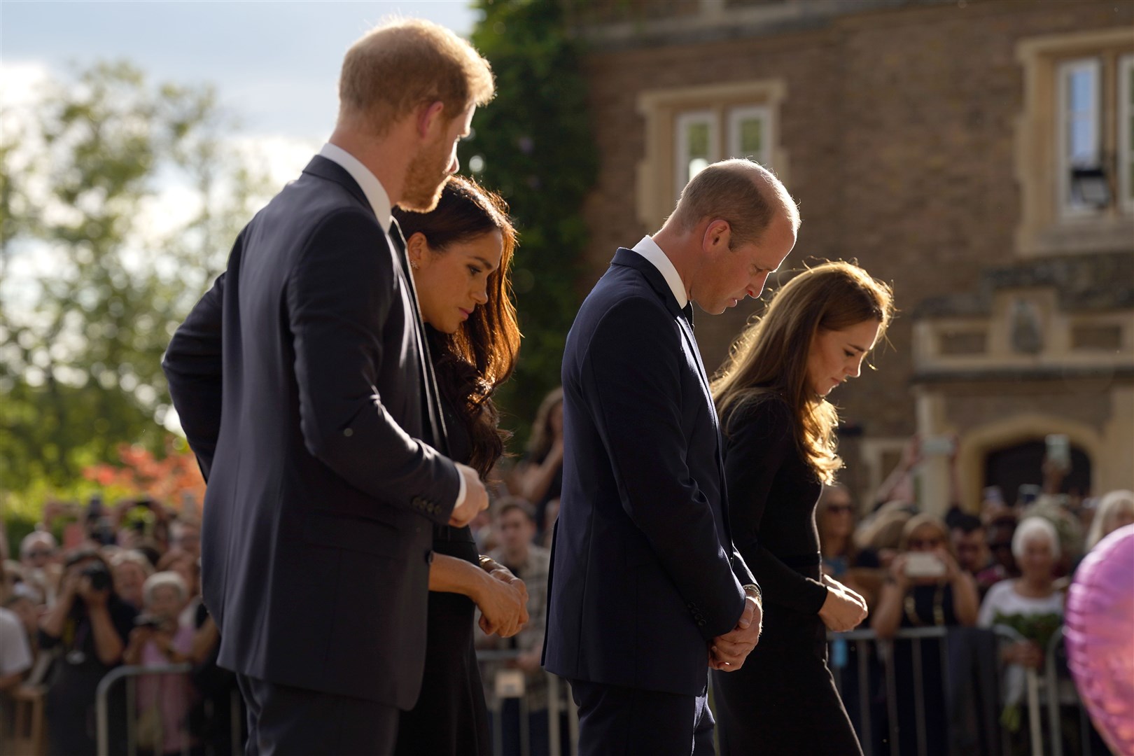 The Duke and Duchess of Sussex and the Prince and Princess of Wales view flowers left by members of the public (Kirsty O’Connor/PA)