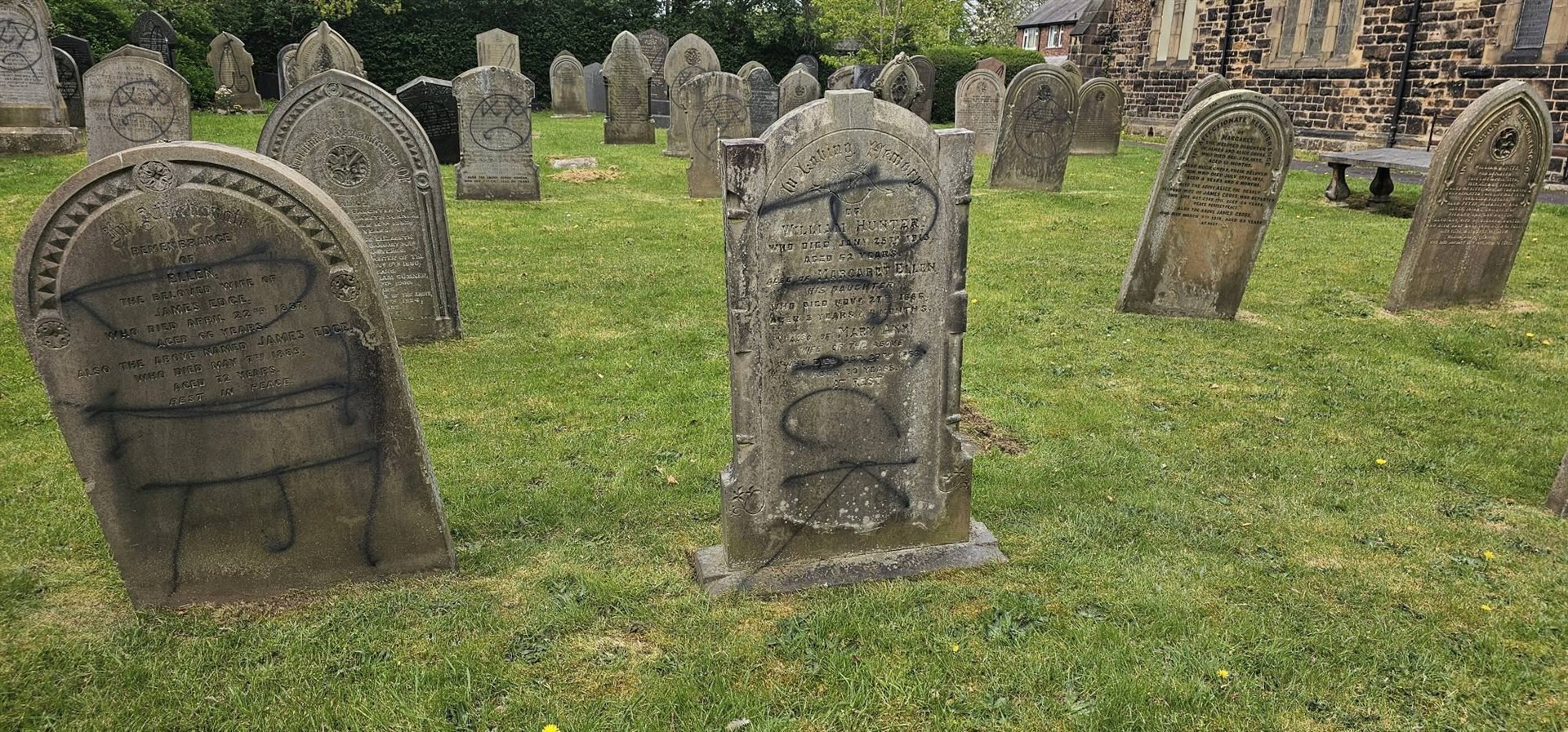 Black spray paint was used to deface gravestones, while red writing was daubed on the walls of the church (Paul Wharton-Hardman/PA)